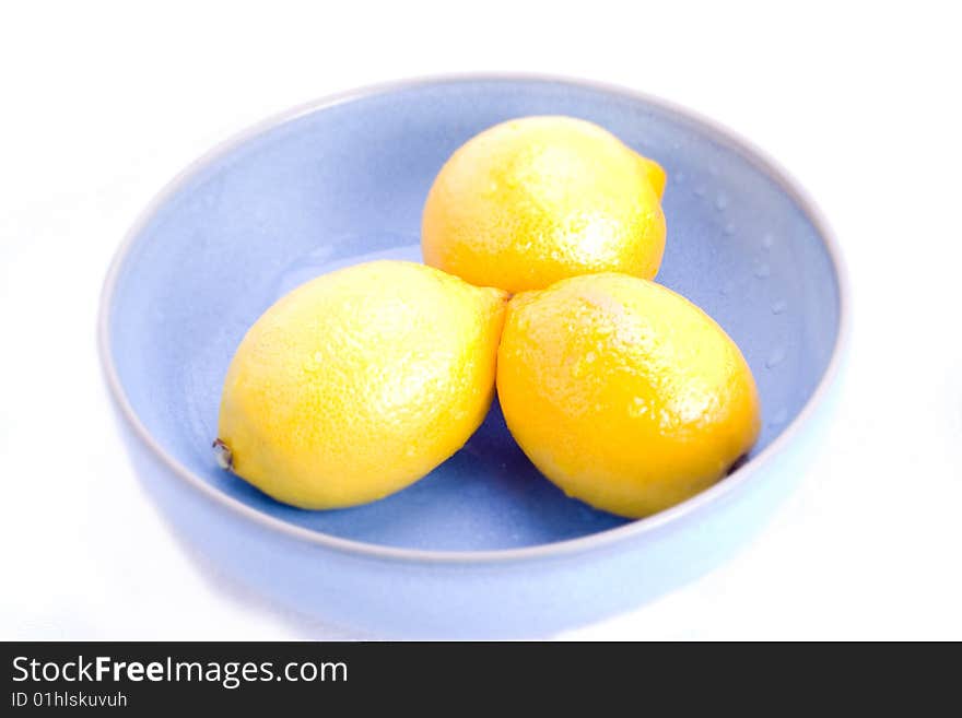 Fresh lemons in blue bowl