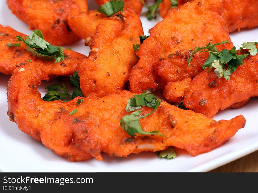 Tasty and spicy fried fish in white plate ready to eat