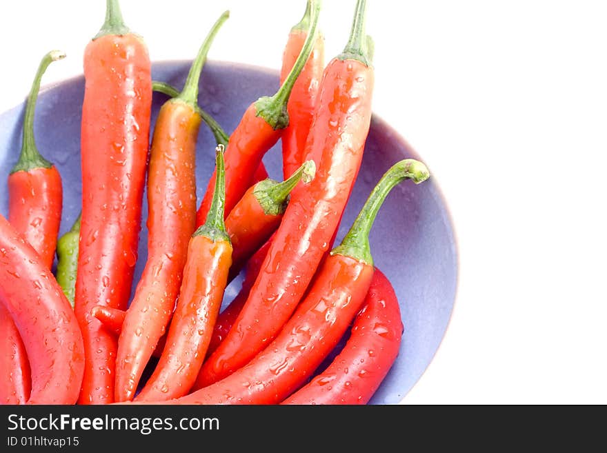 Delicious and fresh red chillies in a bowl on white. Delicious and fresh red chillies in a bowl on white