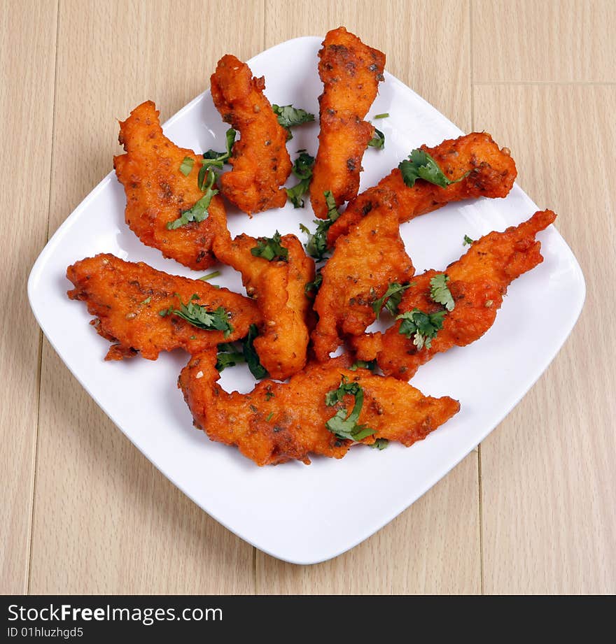 Tasty and spicy fried fish in white plate ready to eat