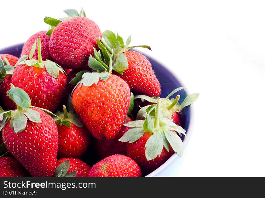 A blue bowl heaped with fresh strawberries. A blue bowl heaped with fresh strawberries