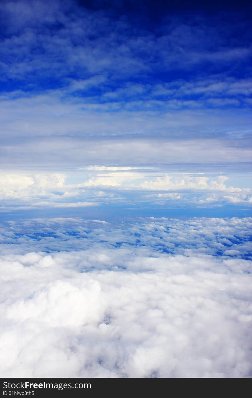 Aerial view of cloudy blue sky from aircraft window. Aerial view of cloudy blue sky from aircraft window.