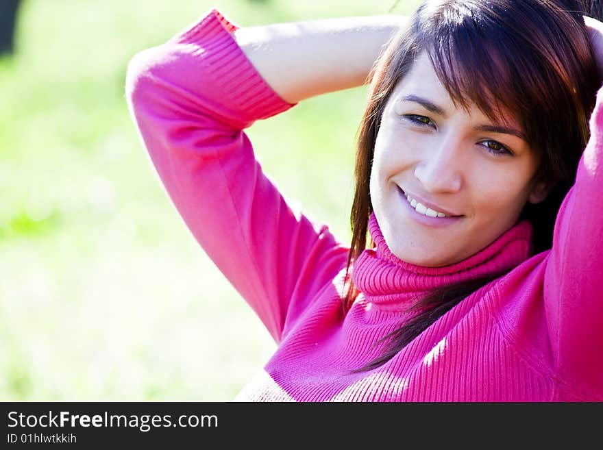 Young smiling woman over green background.