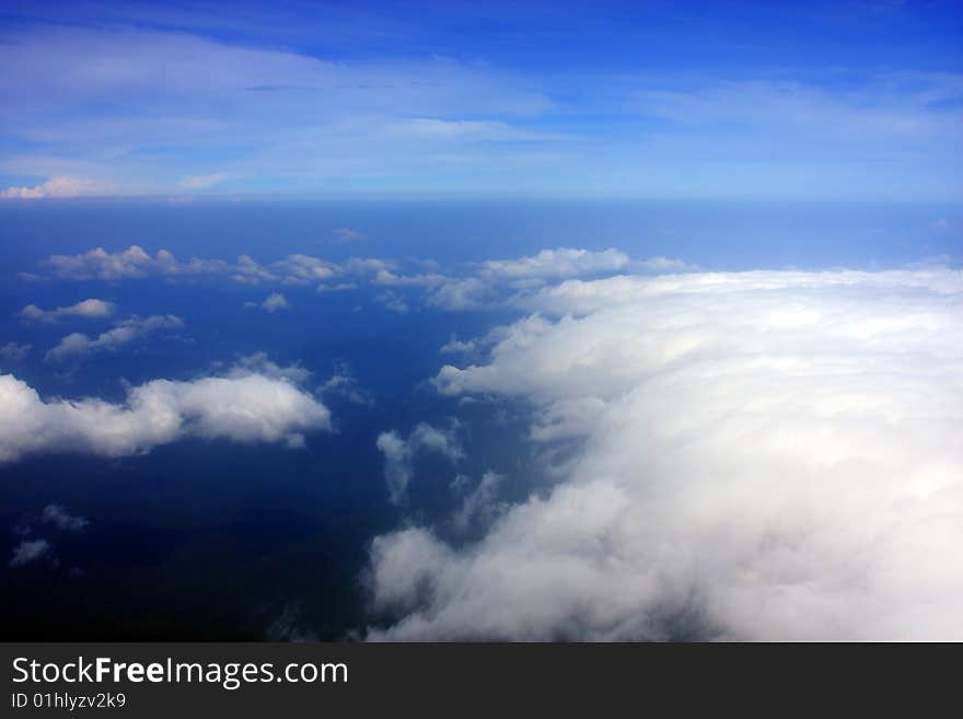 Aerial view of cloudy blue sky from aircraft window. Aerial view of cloudy blue sky from aircraft window.