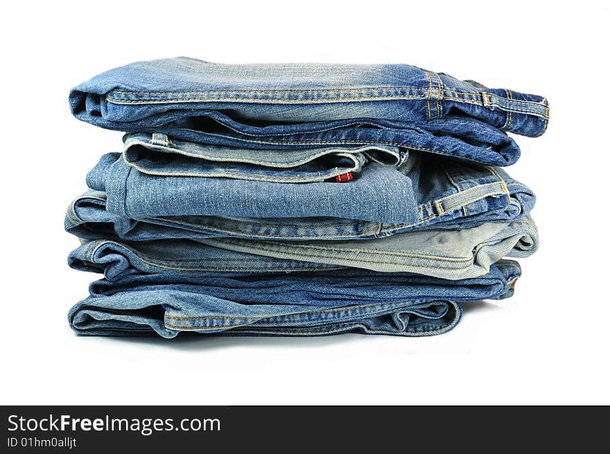 Big bunch of washed-out blue jeans isolated on white background