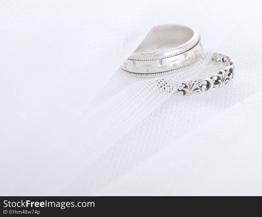 Closeup of wedding rings on a white veil