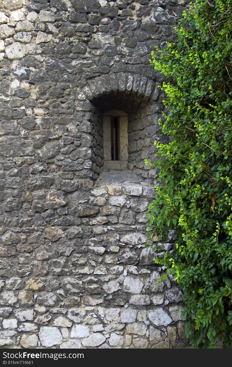 A small window set in a stone wall. A small window set in a stone wall