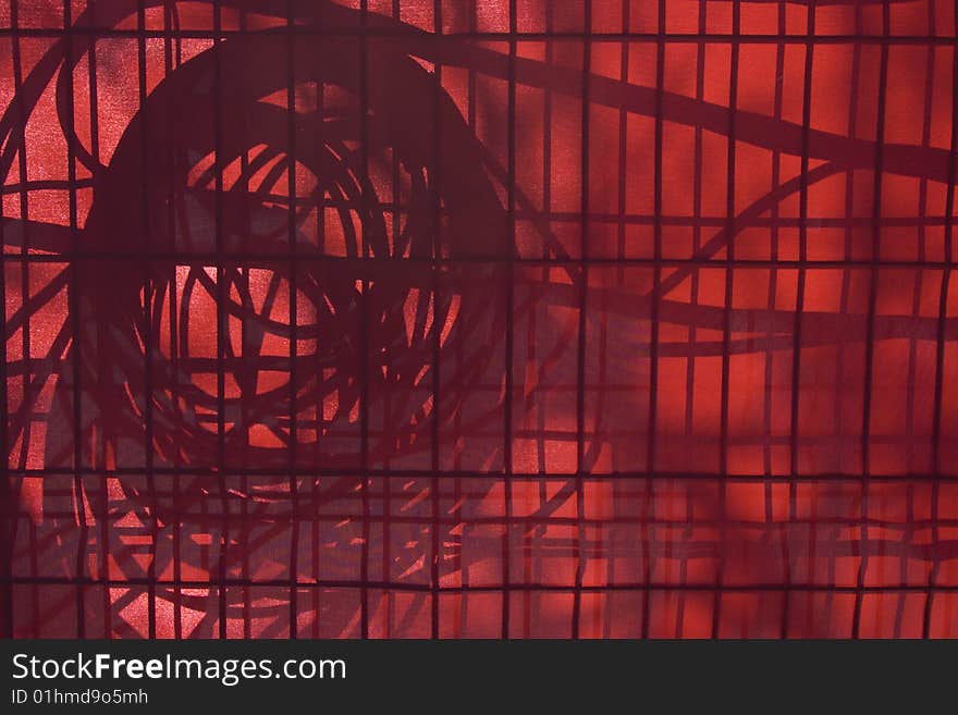 Fence behind a red screen with the shadow of coiled cables, on Montreal's Old Port during the Festival of Light. Fence behind a red screen with the shadow of coiled cables, on Montreal's Old Port during the Festival of Light.