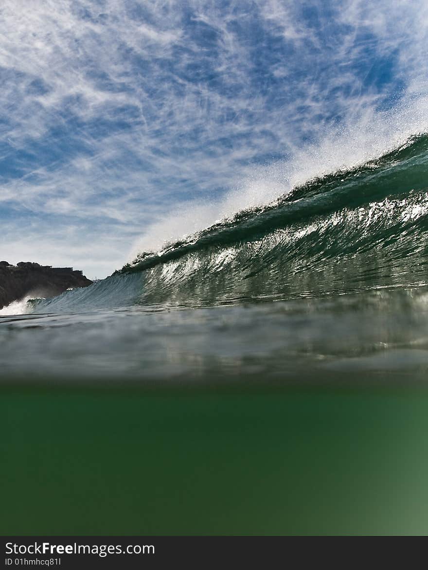 Wave breaking against a crisp sky, partially underwater. Wave breaking against a crisp sky, partially underwater.