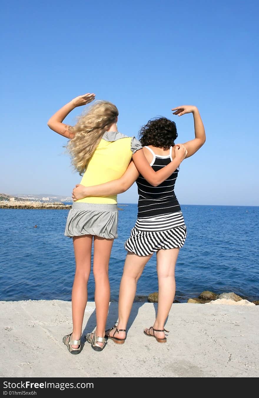 Blond and brunette girls at the sea.