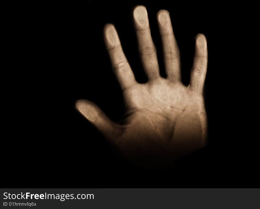 Hand coming through the black background and reaching toward the light