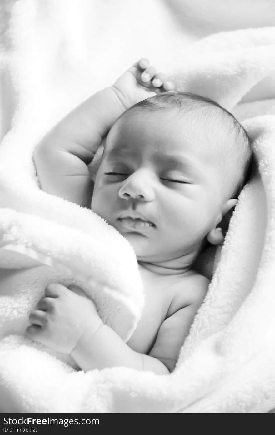 Photo of a baby lying on bed. Photo is black in white. Photo of a baby lying on bed. Photo is black in white