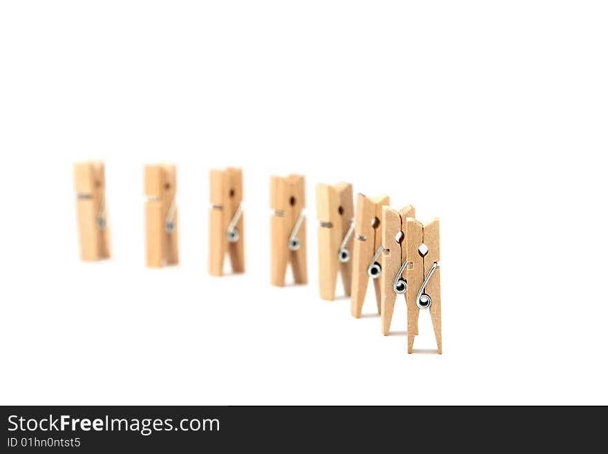 Clothes pegs in formation isolated in white background