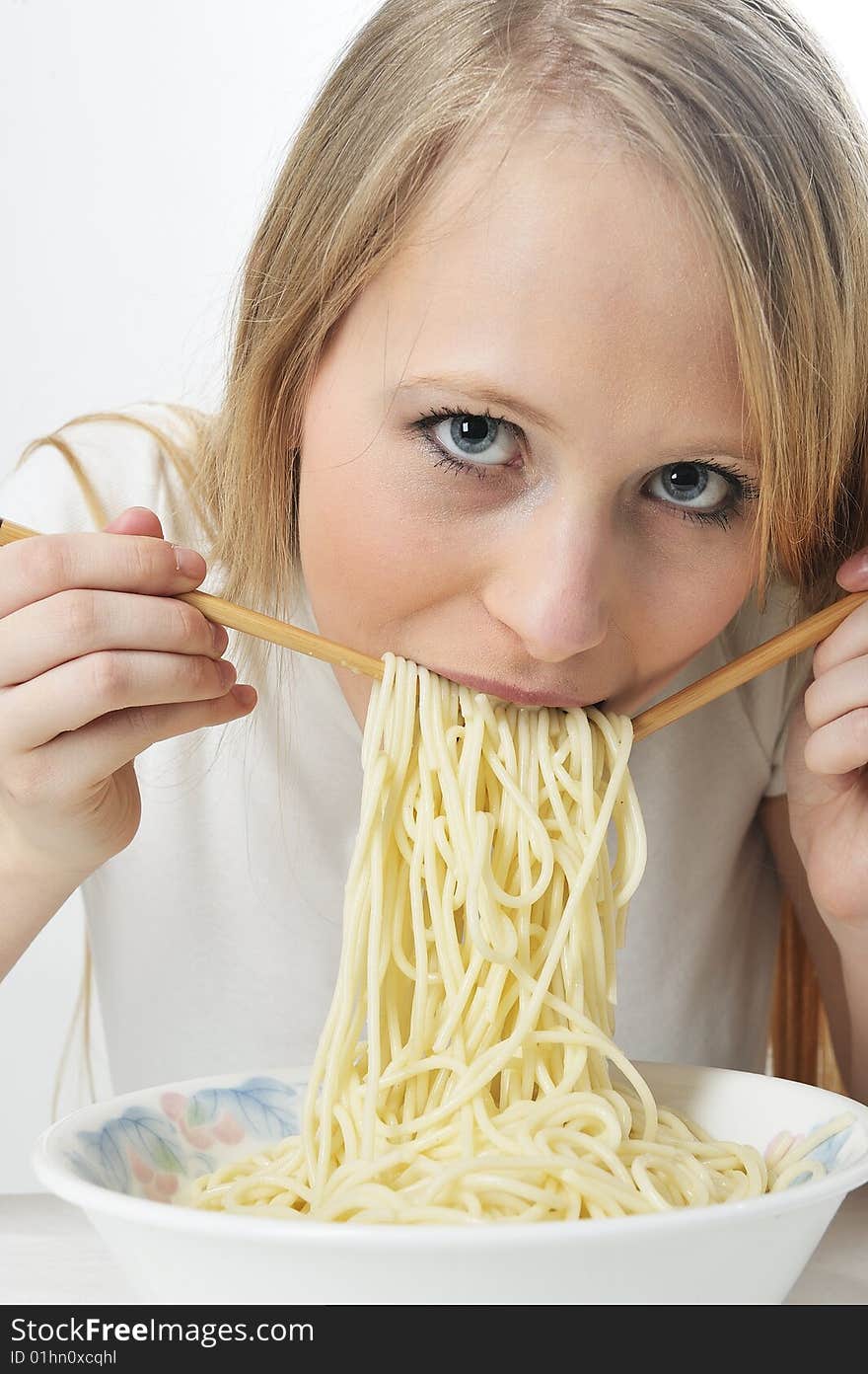 Blond woman use chopsticks eating noodles