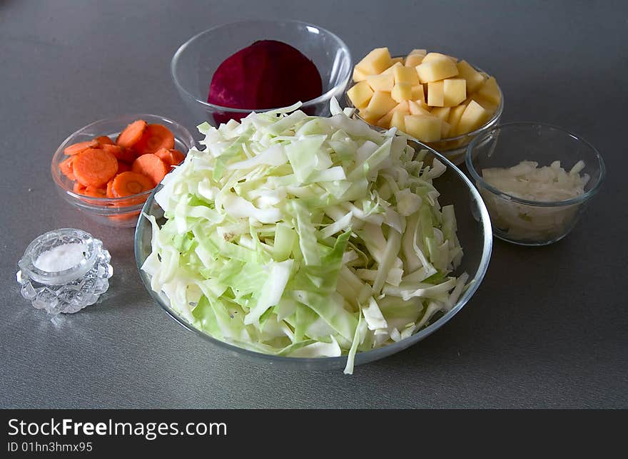 Cuted potato, onion, beet, carrot and cabbage against gray