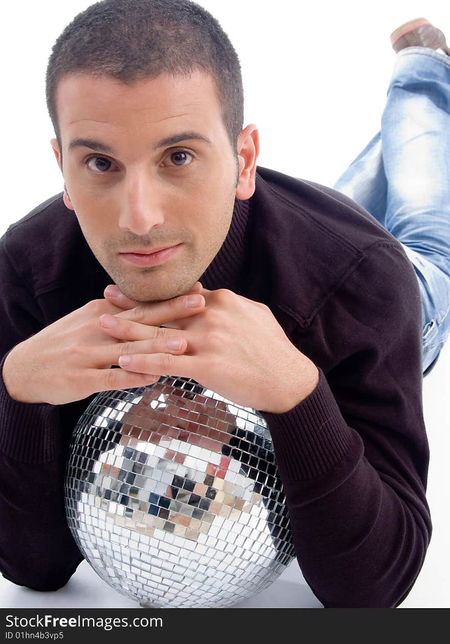 Young guy lying with disco ball on an isolated white background