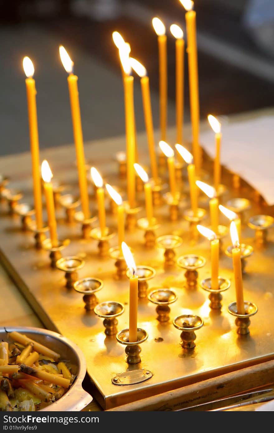 Row of burning candles in church