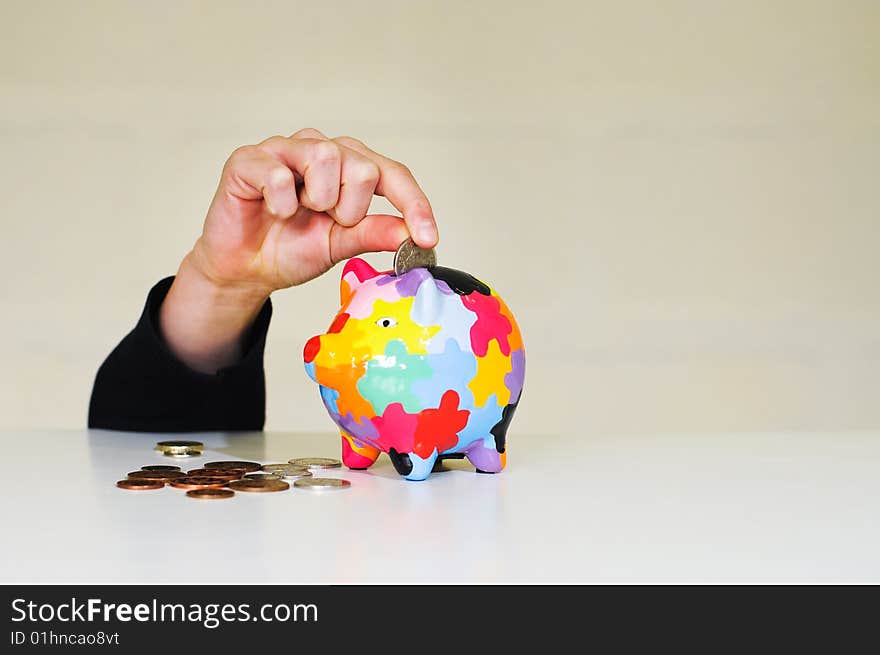 Image of hand putting money in piggybank