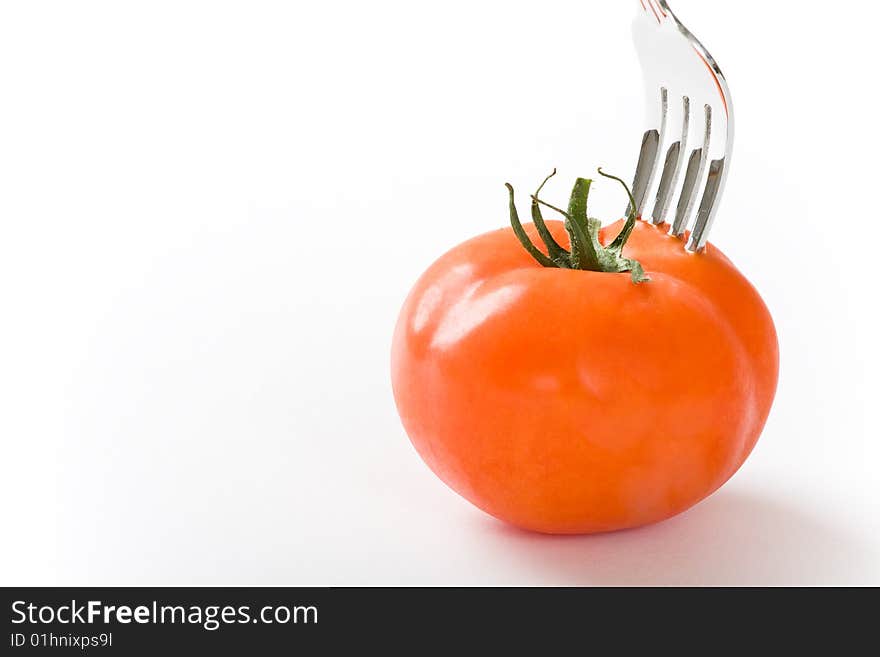 Tomato and fork on white background