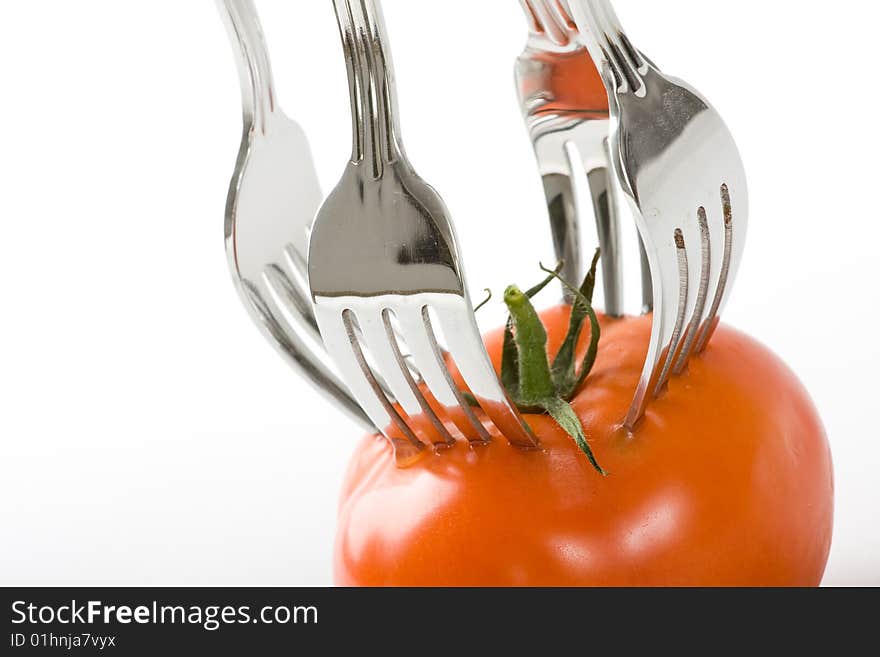 Tomato and fork on white background