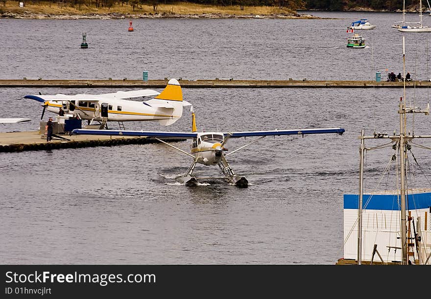 Two sea planes in a busy harbor