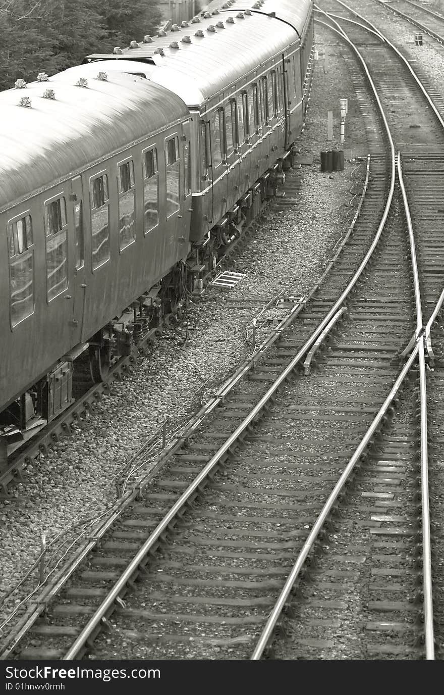 Vintage train carriages with tracks curving into the distance