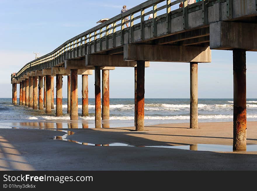 A tall pier itaken in thae late afternoon sunlight with long, deep shadows.