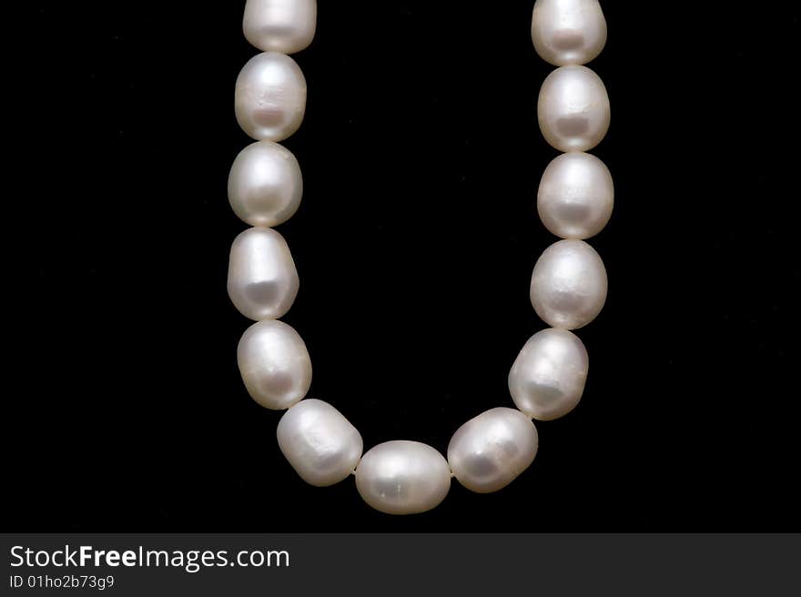 A valuable pearl necelace is in dark background. A valuable pearl necelace is in dark background.