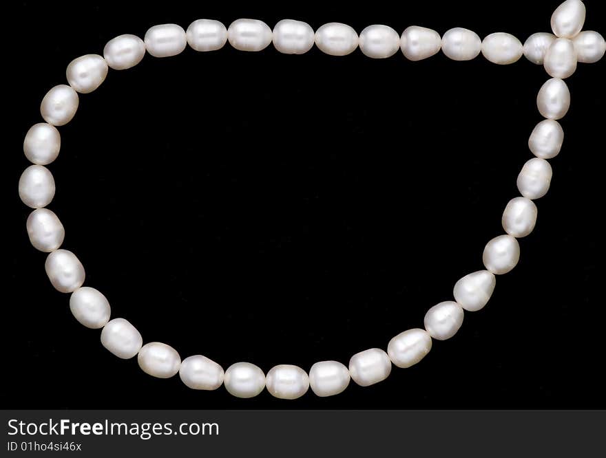 A valuable pearl necelace is in dark background. A valuable pearl necelace is in dark background.