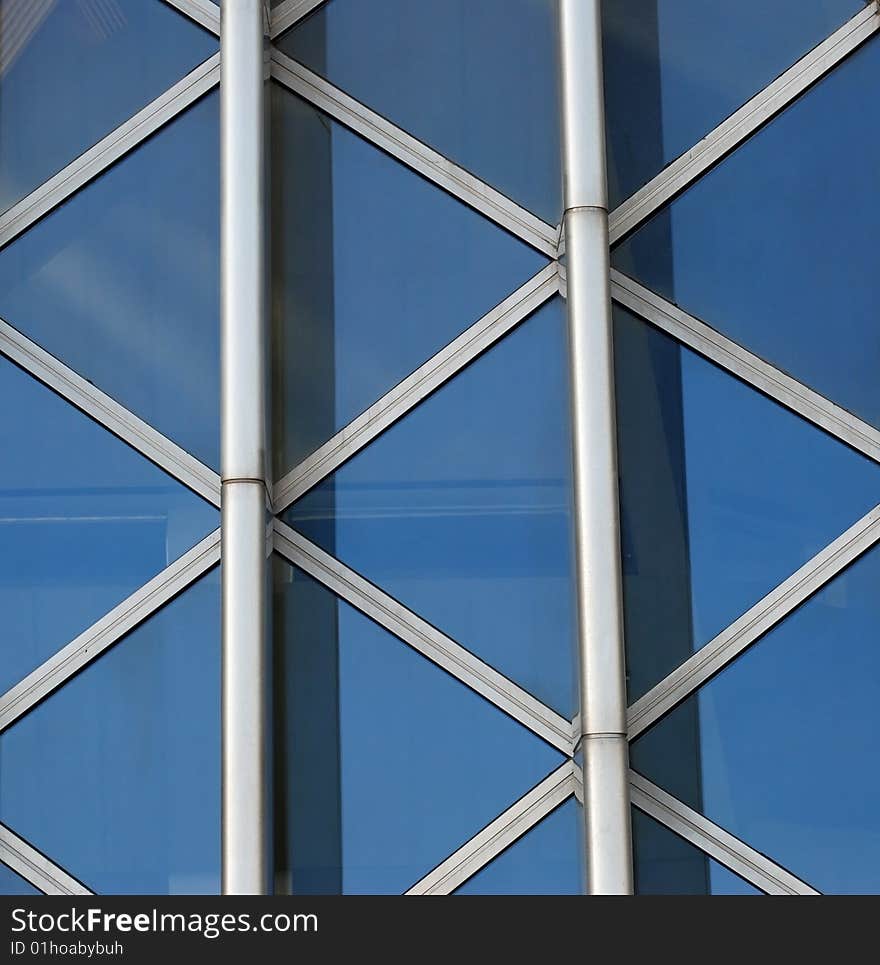 Part of a glass wall framed by steel beams. Part of a glass wall framed by steel beams