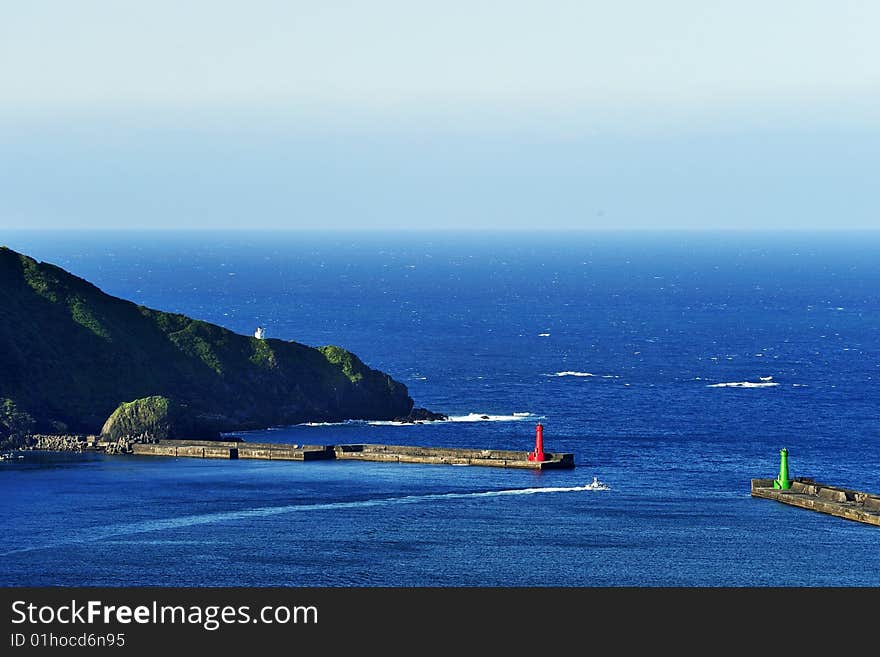 A speedboat passing between two lighthouses