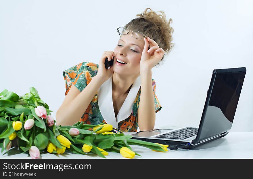 Portrait of the woman of the secretary of office with the flowers and the computer. . Portrait of the woman of the secretary of office with the flowers and the computer.