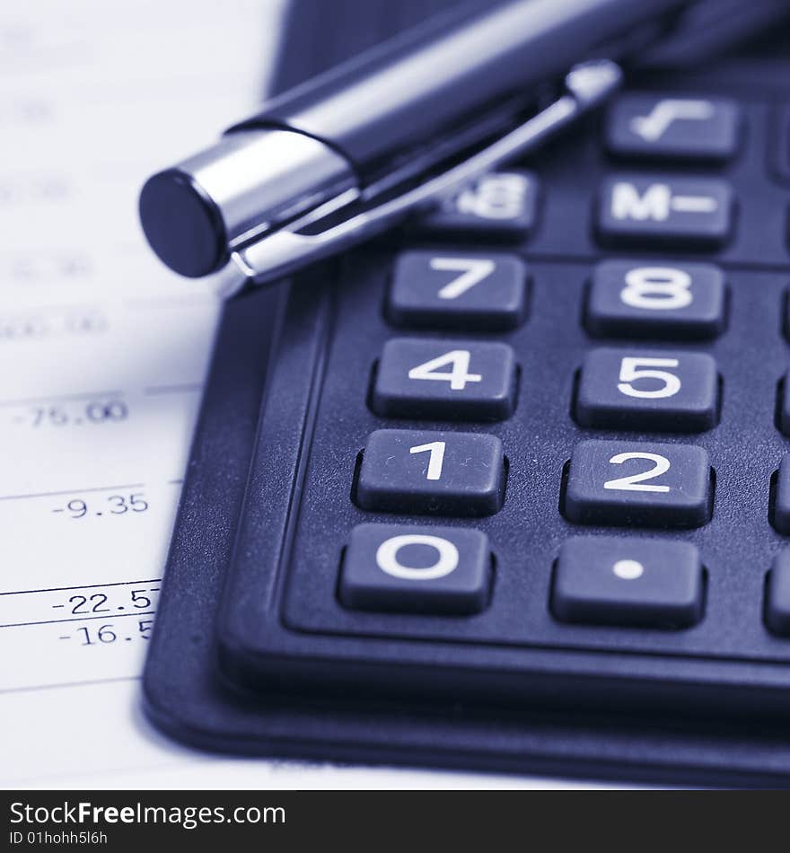 Close up of a calcilator with pen and financial data. Close up of a calcilator with pen and financial data