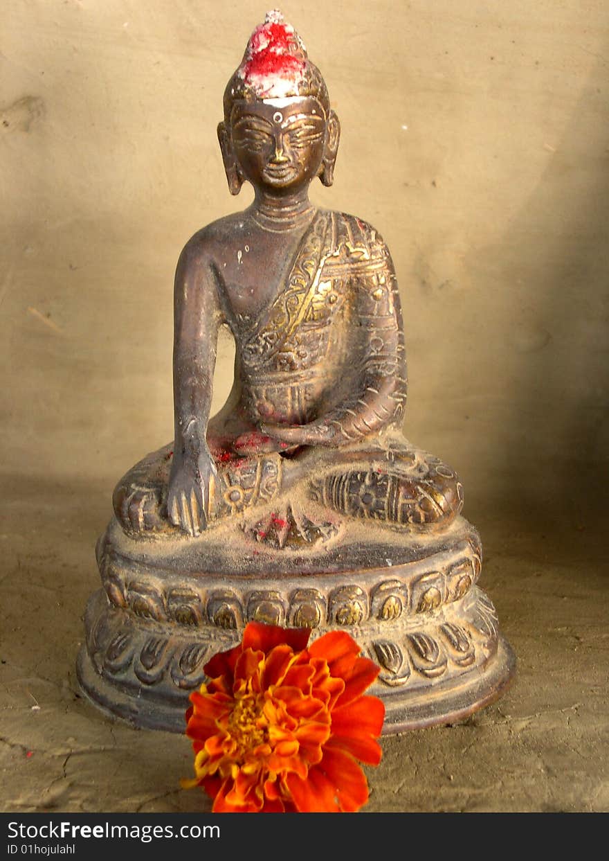 Antique sculpture of lord Buddha with marigold flower. Antique sculpture of lord Buddha with marigold flower