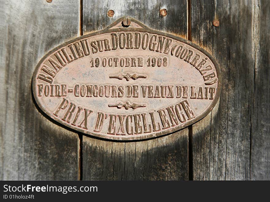 Prize medal from cattle competition hung on barn door in correze, france