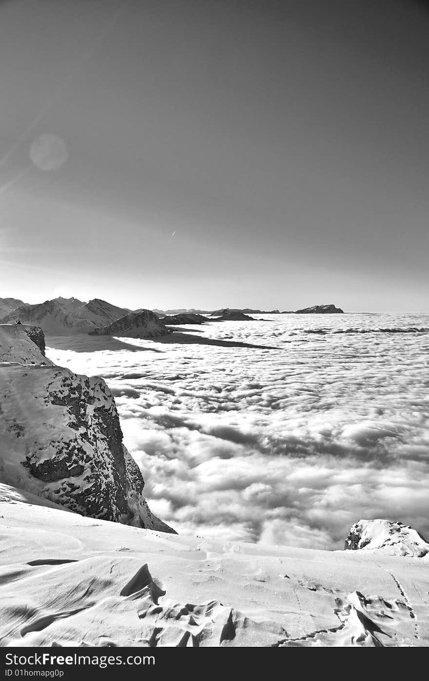 Flying above the alps where the mountain peaks are like islands in a sea of clouds