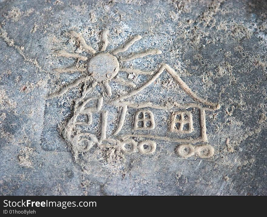 Child's picture on stone is a cottage and sun