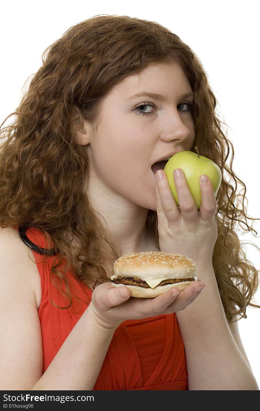 Fastfood or apple, female teenager with red hair choose food