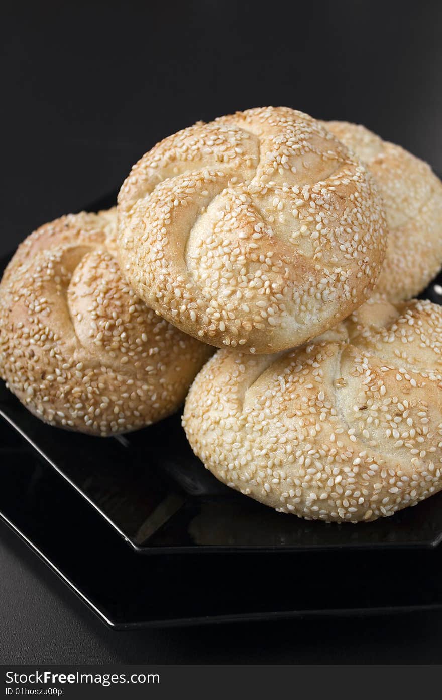 White bread with sesame on a black plate