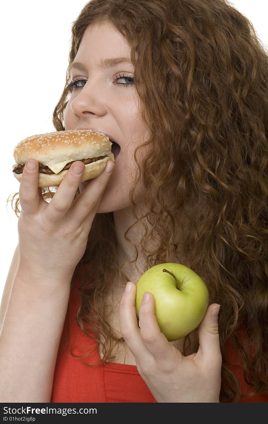 Fastfood or apple, female teenager with red hair choose food