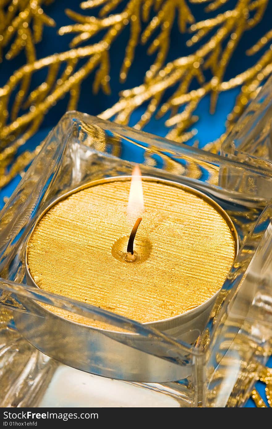 Golden candle in glass with water