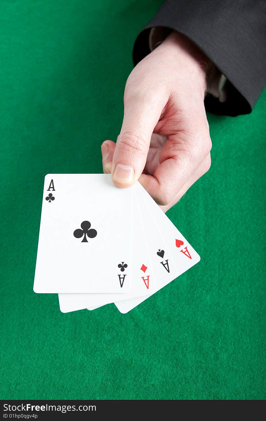 Card player holding all four aces on a green cloth. Card player holding all four aces on a green cloth