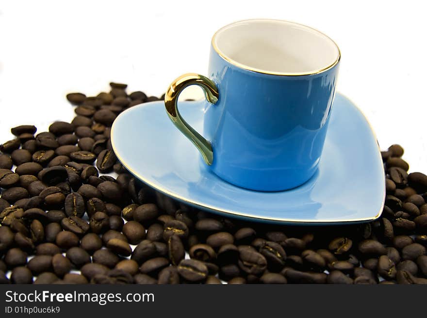 Blue cup and saucer with grains of coffee