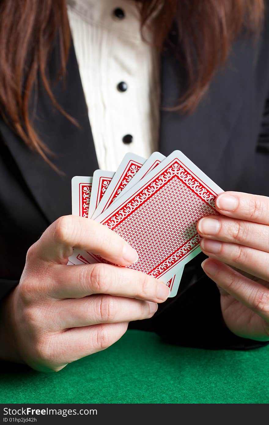 Woman holding 5 red cards about to place a card on the table. Woman holding 5 red cards about to place a card on the table