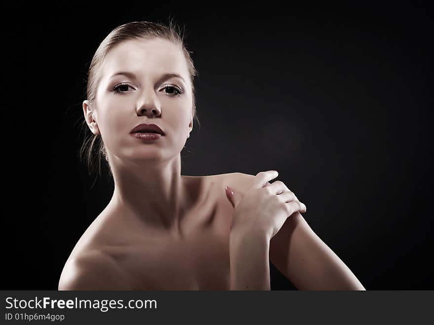 Portrait of young beautiful woman at black background