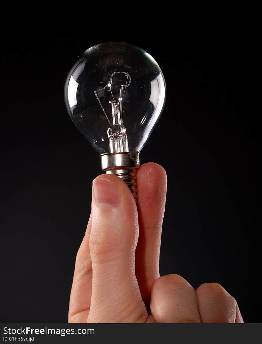 Electric lamp in male fingers