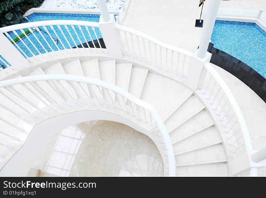 The curving staircase and upward steps in a luxury hotel lobby atrium.