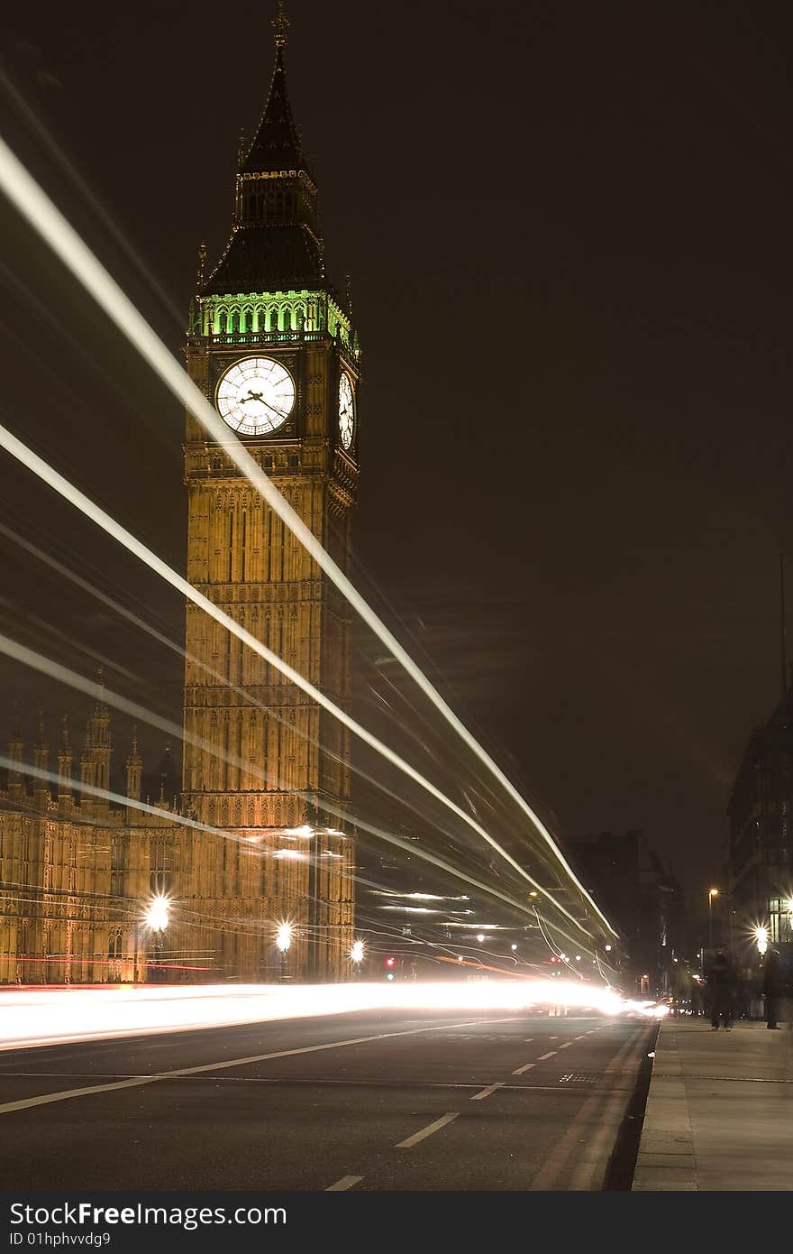 The famous Big Ben at night. The Big Ben is located in London England. The white stripes are from cars that drive by.