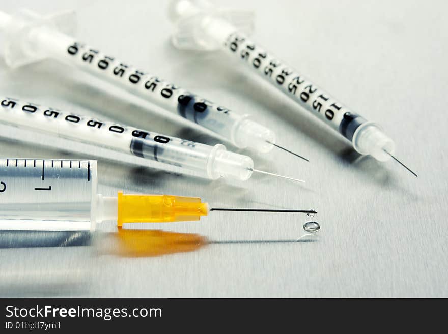 Syringes with hypodermic needle metal background. Syringes with hypodermic needle metal background