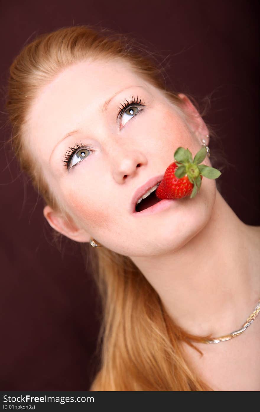 Blond woman with strawberry in mouth. Blond woman with strawberry in mouth